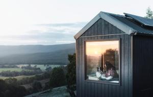 a woman and a dog sitting in a window at Hidden Off-Grid Escape with Epic Views - Orla in Warrenmang