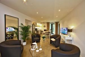 a living room with two chairs and a table at Les Jardins du Porche in Sarlat-la-Canéda