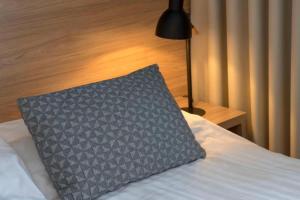 a pillow sitting on top of a bed with a lamp at Hotel Gullfoss in Haukadalur