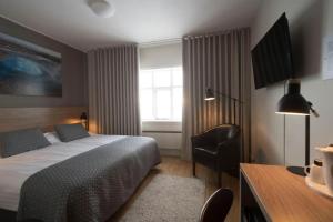 a bedroom with a bed and a desk and a window at Hotel Gullfoss in Haukadalur