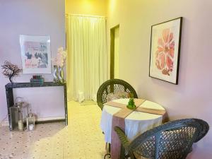 a room with a table and chairs and a mirror at Cozy Apartment in Kololi