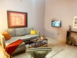 a living room with a couch and a tv at Cozy Apartment in Kololi