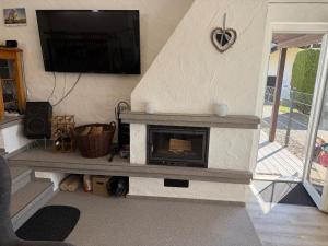 a living room with a fireplace with a tv on the wall at Ferienhaus Stausee Bitburg in Biersdorf am See