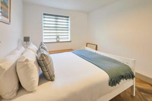 a bedroom with a white bed with pillows and a window at Host & Stay - Middle Cottage in Seahouses
