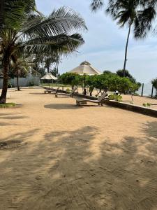 a group of picnic tables with umbrellas on a beach at Tropical Accommodations in Kandana