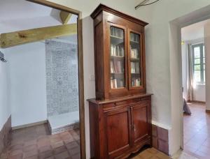 a wooden cabinet in a living room with a mirror at Charmante maison en Camargue avec piscine partagée in Saintes-Maries-de-la-Mer