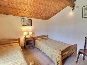a bedroom with two beds and a nightstand with a table at Charmante maison en Camargue avec piscine partagée in Saintes-Maries-de-la-Mer +18 photos