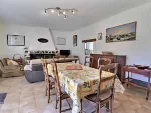 a living room with a table and a couch at Charmante maison en Camargue avec piscine partagée in Saintes-Maries-de-la-Mer