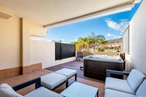 a balcony with a jacuzzi tub and chairs at Townhouse Playa Negra in Puerto de Santiago