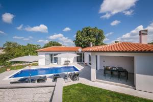 a backyard with a swimming pool and a house at Holiday house NaNa in Marčana