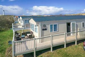 a mobile home on a deck with a railing at Beach life in Lossiemouth