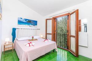 een slaapkamer met een bed en een groot raam bij Le Dalie With Shared Pool - Happy Rentals in Marinella +24 foto's