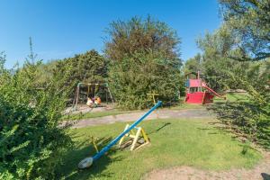 een park met twee schommels en een speeltuin bij Le Dalie With Shared Pool - Happy Rentals in Marinella