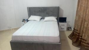 a bedroom with a large bed with a large headboard at Marongs Appartment in Djalabango