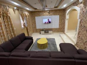 a living room with a couch and a tv at Marongs Appartment in Djalabango