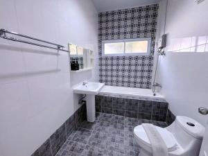 a white bathroom with a toilet and a sink at Sky View Resort Buriram in Buriram