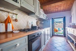 a kitchen with white cabinets and a stove top oven at Una Mansarda Nell'isola - Happy Rentals in La Maddalena