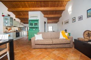 a living room with a couch and a kitchen at Una Mansarda Nell'isola - Happy Rentals in La Maddalena +16 photos