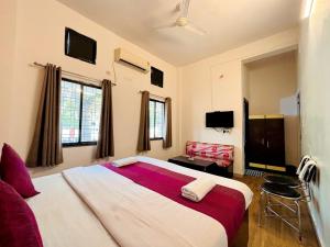 a bedroom with a large bed and a chair at Hotel Sunrise Inn in Kota