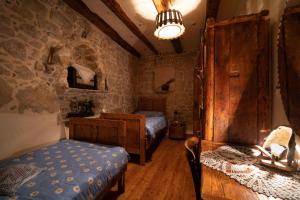 a bedroom with two beds and a stone wall at Holiday Home Leptir in Drniš