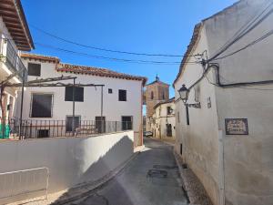 an alley in an old town with white buildings at Casa Rural La Torre in Chinchón