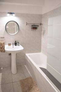 a white bathroom with a sink and a bath tub and a sink at Seaview Anteia's Central Finikoudes Apt in Larnaca in Larnaka +29 photos