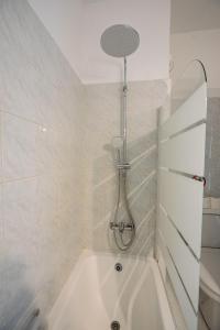 a white bath tub with a shower in a bathroom at Seaview Anteia's Central Finikoudes Apt in Larnaca in Larnaka