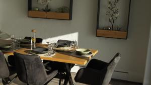 einen Esstisch mit Stühlen und einen Holztisch mit Gläsern in der Unterkunft Ferienhaus Magnolie in der Eifel in Monschau