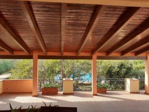 a covered patio with a wooden ceiling and plants at Casa Vacanze Vista Mare-Piscina - PORTO ROTONDO in Porto Rotondo
