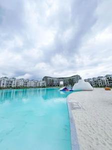 a swimming pool with blue water in front of buildings at Ls apartment in Midrand