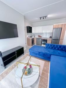 a living room with a blue couch and a table at Ls apartment in Midrand +3 photos