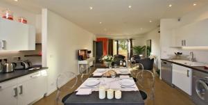 a kitchen with a table and chairs in a room at Les Jardins du Porche in Sarlat-la-Canéda
