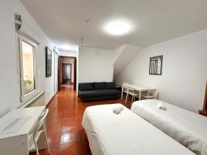 pokój z dwoma łóżkami i kanapą w obiekcie Residencial Art Brut w mieście Castellón de la Plana