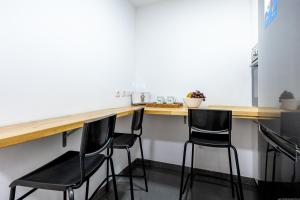 a kitchen with black chairs at a wooden counter at Townhouse Playa Negra in Puerto de Santiago +28 photos