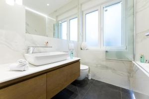 a white bathroom with a sink and a toilet at Fortuna Luxury Rooms 1 in Split +21 photos