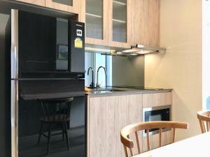 a kitchen with a stove and a counter with chairs at Gateaway sukhumvit 42 home in Bangkok