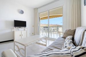 a living room with a couch and a table at Los Flamencos I in Miami Platja