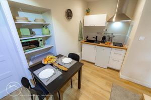 a small kitchen with a table with fruit on it at Les vieilles tours Bellevue Parking in Chambéry