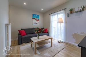 a living room with a couch and a table at Les vieilles tours Bellevue Parking in Chambéry