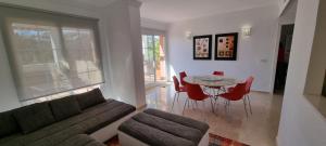 salon z kanapą, stołem i krzesłami w obiekcie Mijas Golf penthouse w mieście Santa Fe de los Boliches