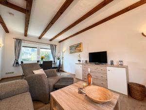 ein Wohnzimmer mit Sofa und Fernseher in der Unterkunft Elke in Tinnum