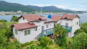 a row of houses on a hill with the water at Tongyoung Mongdolhouse Pension in Tongyeong +4 photos