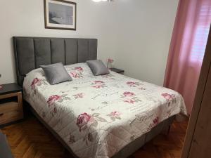 a bedroom with a bed with pink flowers on it at Apartments Julija in Vela Luka