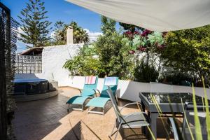 a patio with chairs and a table and a grill at Carvoeiro Beach Apartment in Carvoeiro