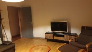 un salon avec une télévision et un canapé dans l'établissement Mt St Martin ,1er étage, 3 lits doubles séparés, à Mont-Saint-Martin