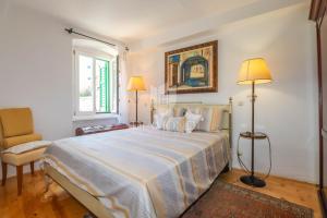 a bedroom with a large bed and a chair at Villa Augusta Ferri in Rovinj