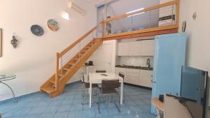 a kitchen with a staircase and a table in a room at Magarà Apartment by Casa in mente in Cefalù