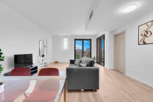 a living room with a gray couch and red chairs at Cefalonia Garden with Terrace & Garage by NDP rent in Milan