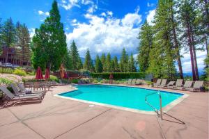 a swimming pool with chaise lounge chairs at Chimney Rock Condo condo in Stateline