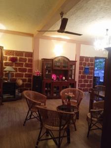 a living room with chairs and a table and a brick wall at Shemera Villa in Beruwala